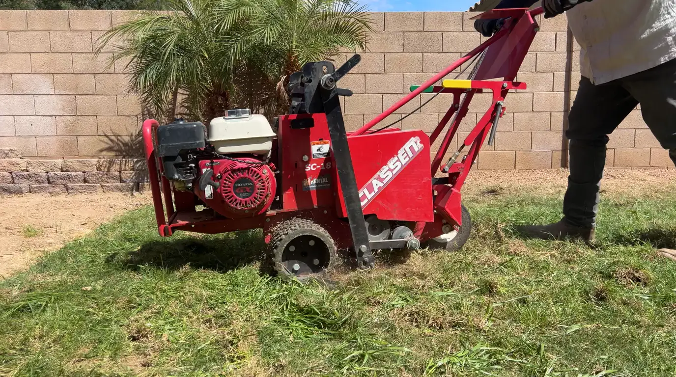A sod cutter removing the old grass from an Arizona backyard before turf installation