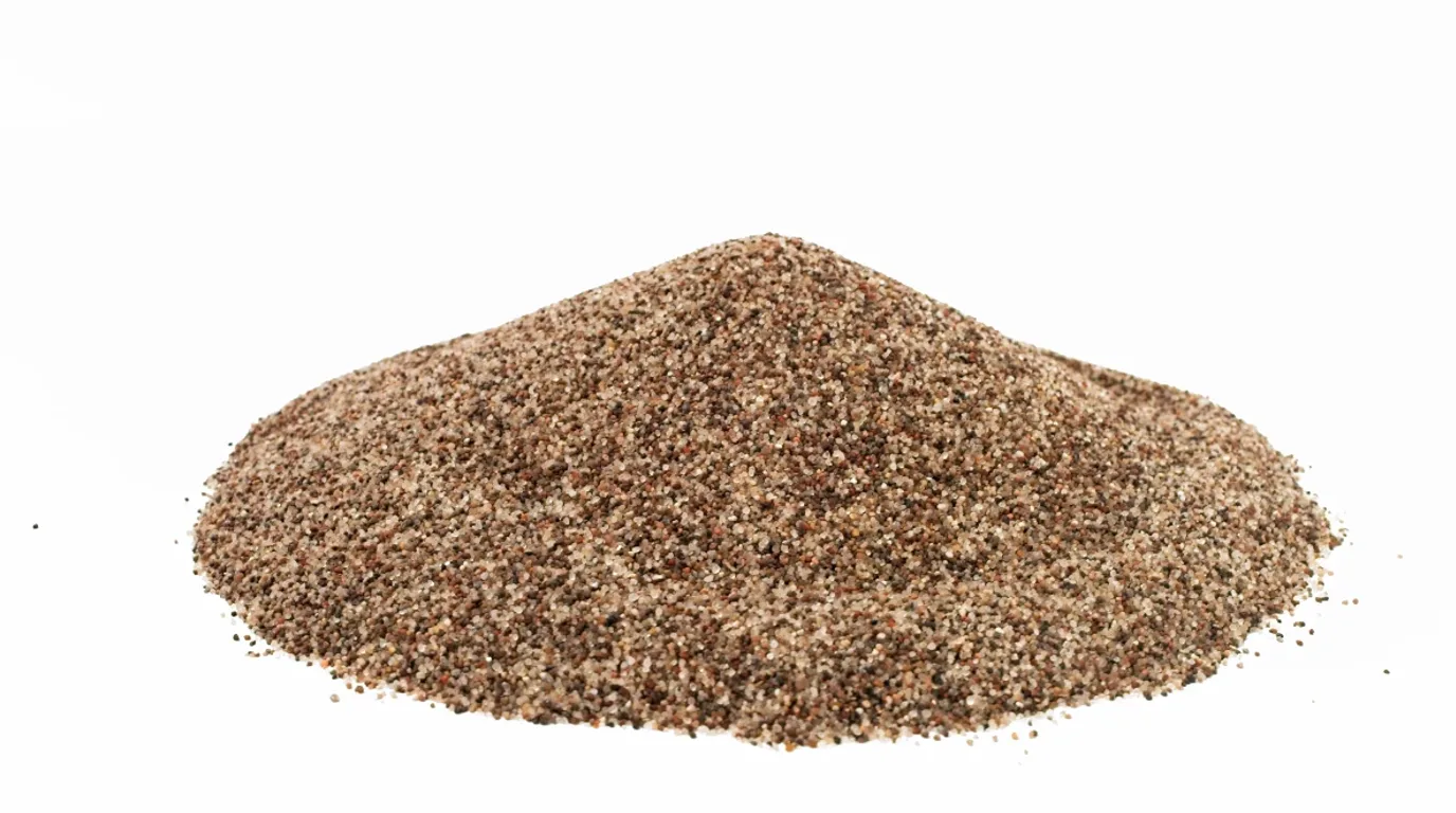 A pile of tan and brown turf infill granules on a clean white background
