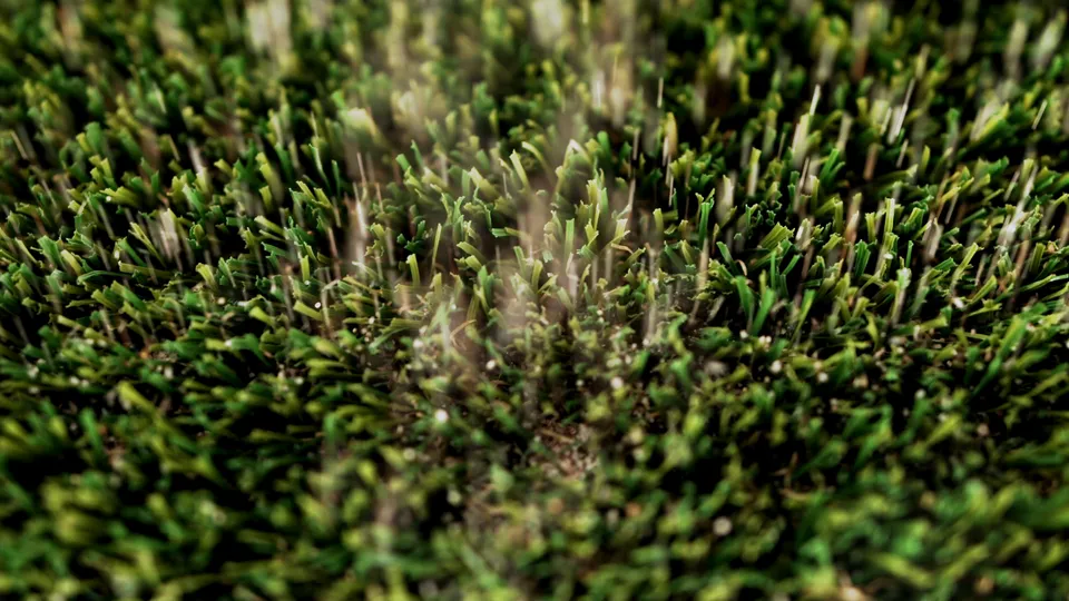 Close-up of infill granules settled between artificial turf blades