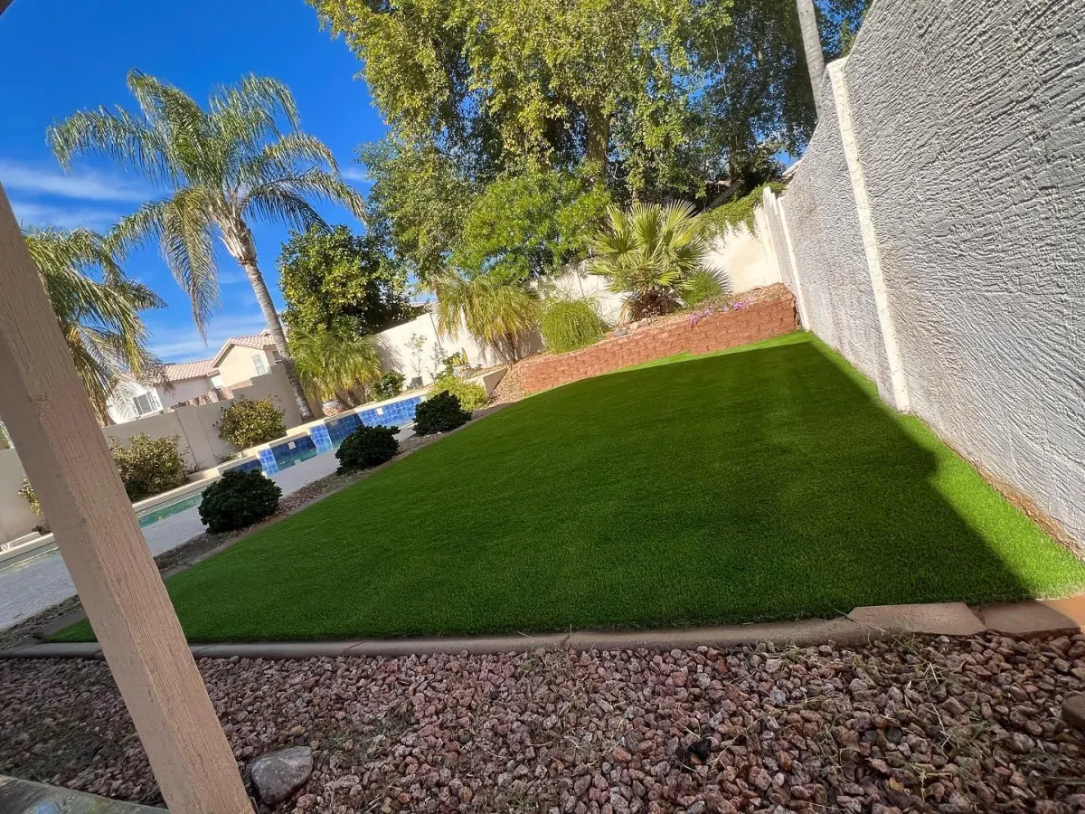 The same backyard with a lush green artificial turf lawn after installation by The Turf Yard